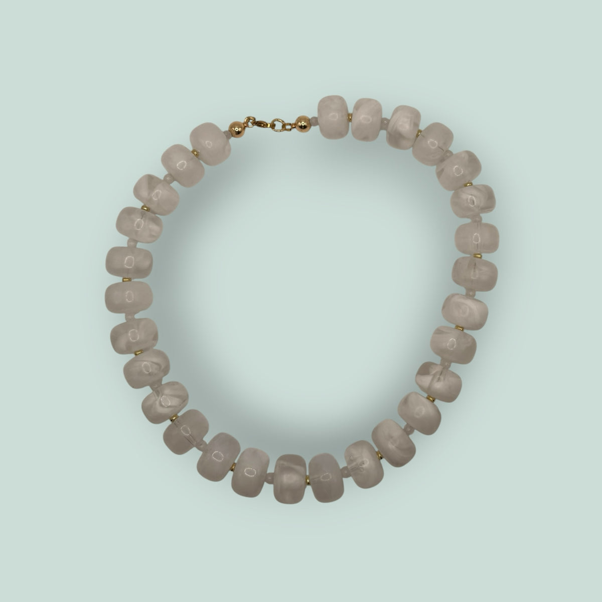 The Salty Bead Co handcrafted statement necklace featuring milky white semi-translucent beads and gold-toned spacers.